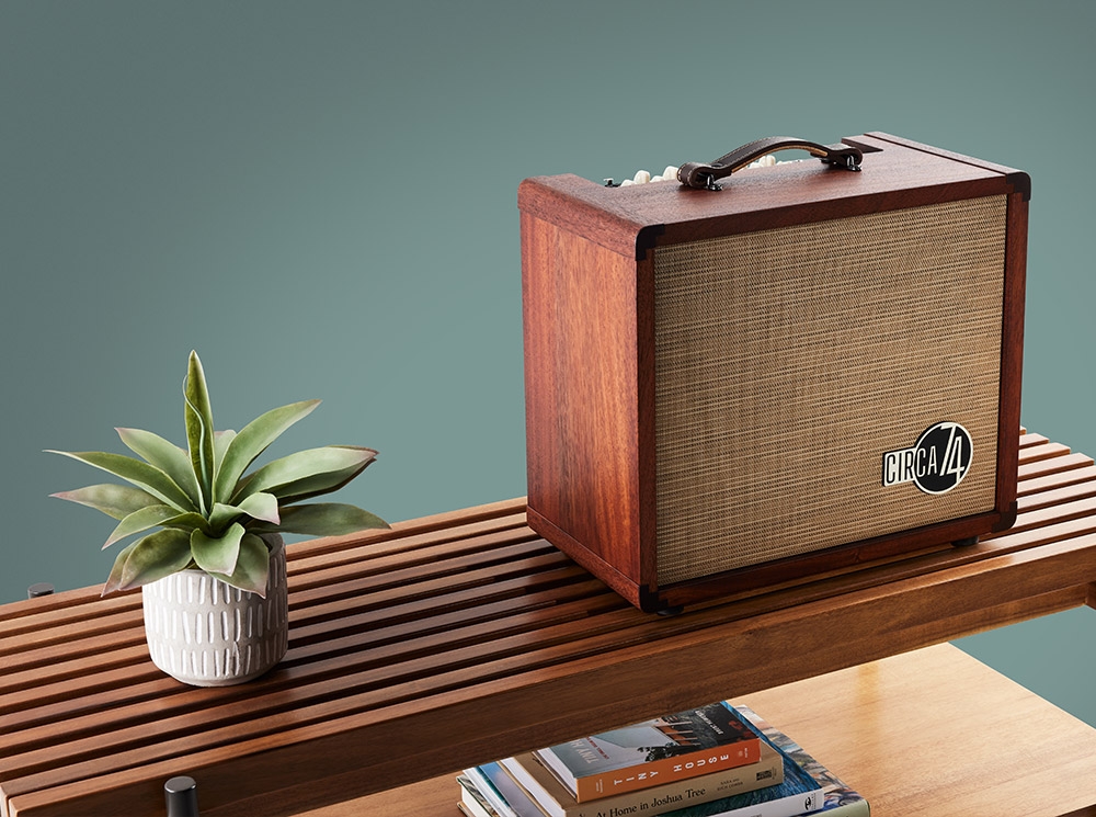 Amp sitting on top of a bench with a plain blue background